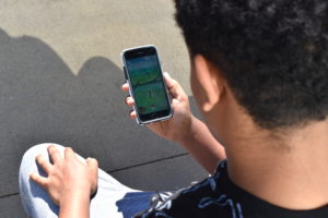 A student playing Pokêmon Go by JD Le Roy 