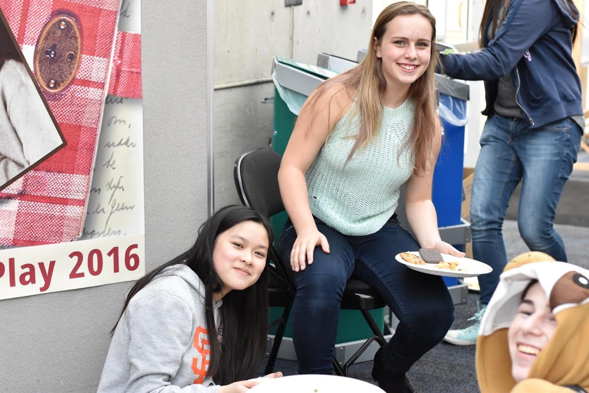 Two cast members eating pizza outside the theater during a rehearsal. Photo by Zelda Perkins